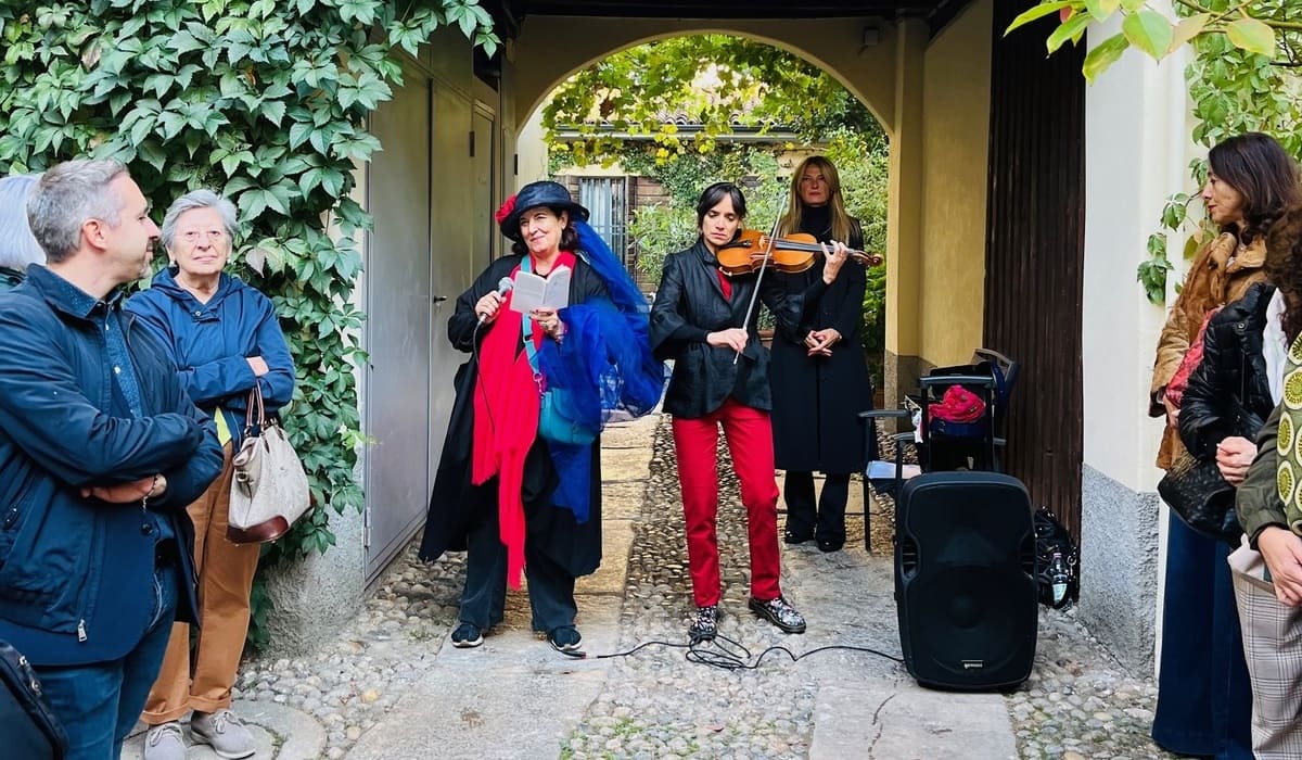 Donatella Massimilla, a sinistra, direttrice artistica dello Spazio Alda Merini, recita i versi della poetessa durante una passeggiata di Cortili Aperti.