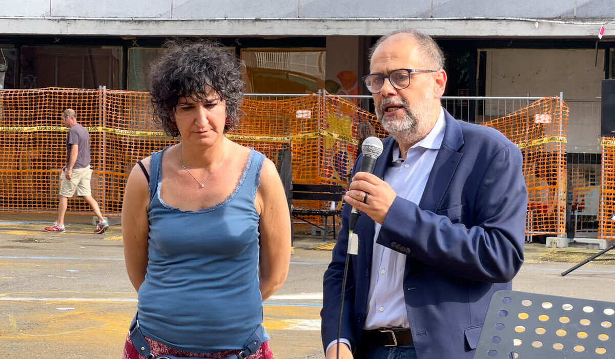 Marco Granelli, assessore ai Lavori pubblici  e Nadia Fulco, responsabile progetti sociali Atir Teatro Ringhiera con alle spalle il teatro Ringhiera e la recinzione dei lavori ancora sospesi 