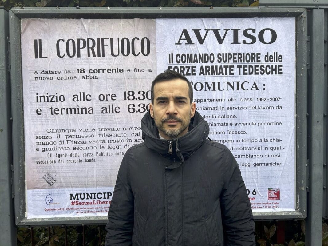 Il presidente del Municipio 6 Santo Minniti davanti ai manifesti dell'occupazione nazista a Milano.